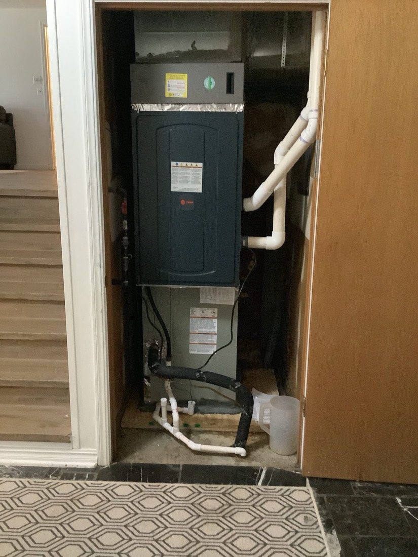 Complete HVAC furnace and water heater installation with white piping
