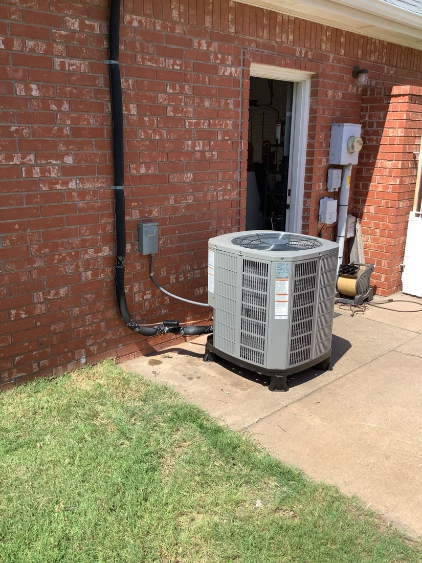 New outdoor AC condenser unit installed at residential property