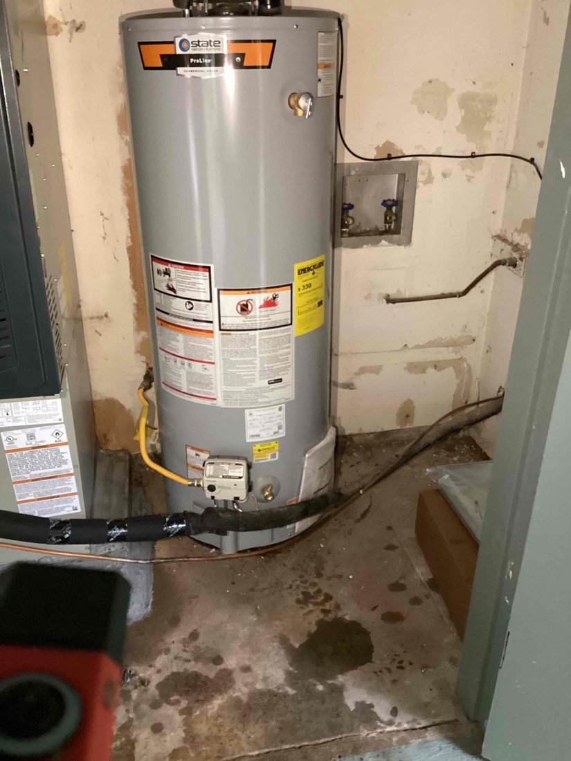 New State water heater installed with proper plumbing connections.