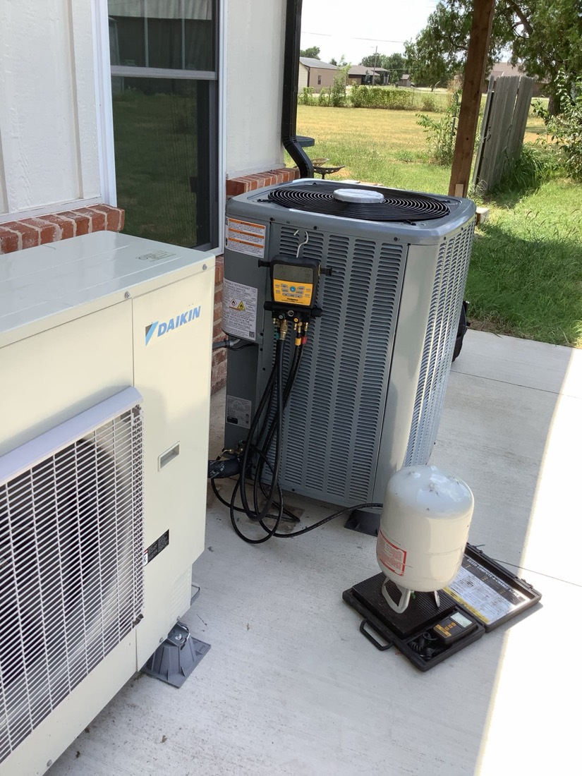 Installed Daikin air handler and condensing unit with refrigerant lines.