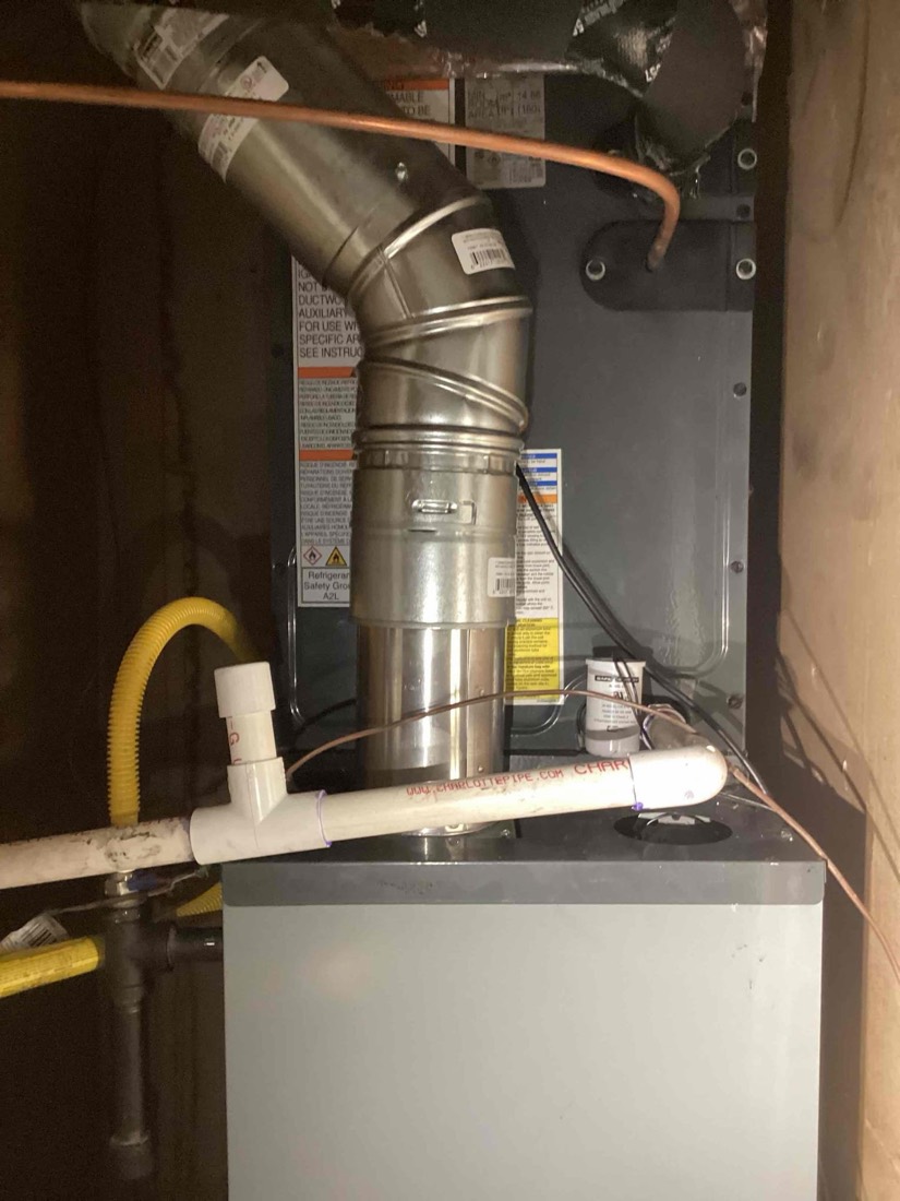 HVAC furnace unit with metal ductwork and refrigerant lines inside home