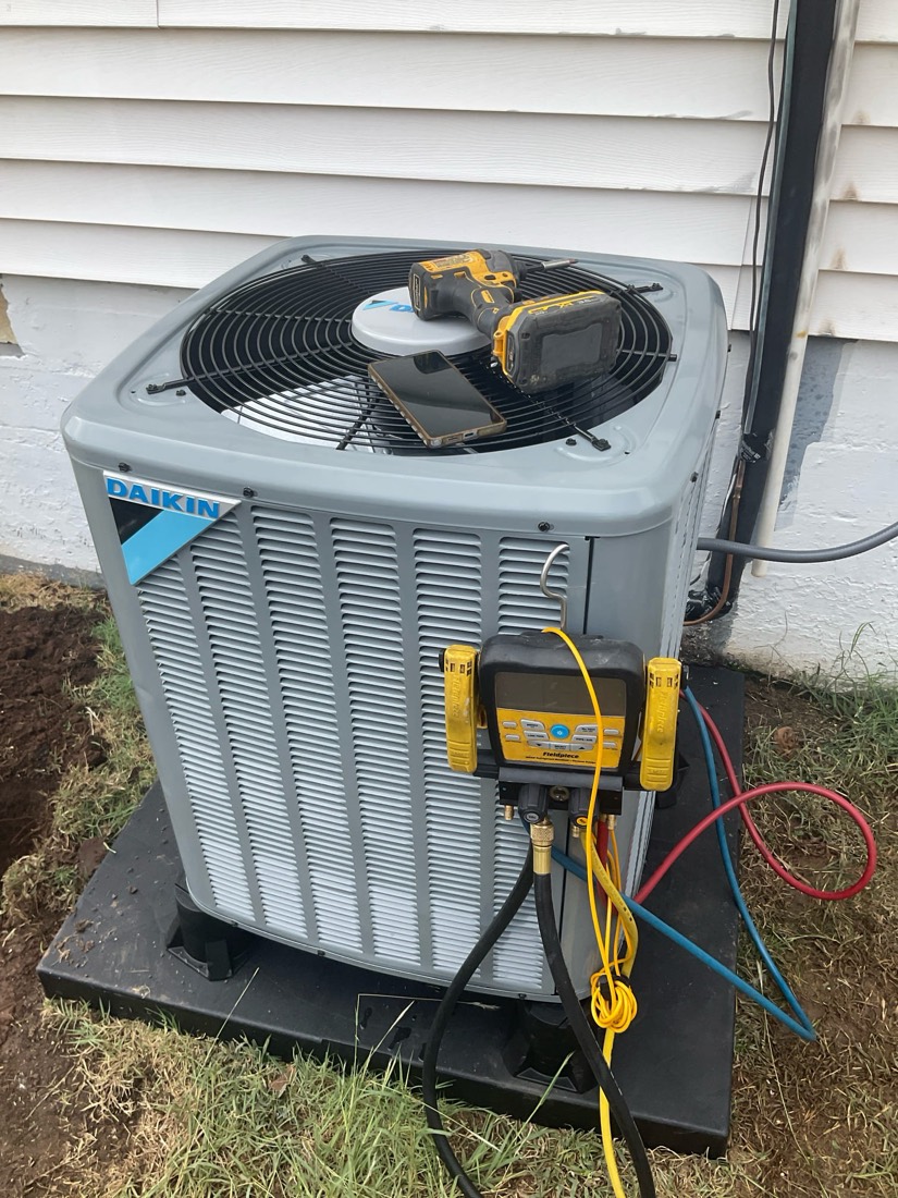 Daikin AC unit mounted on pad with test equipment.