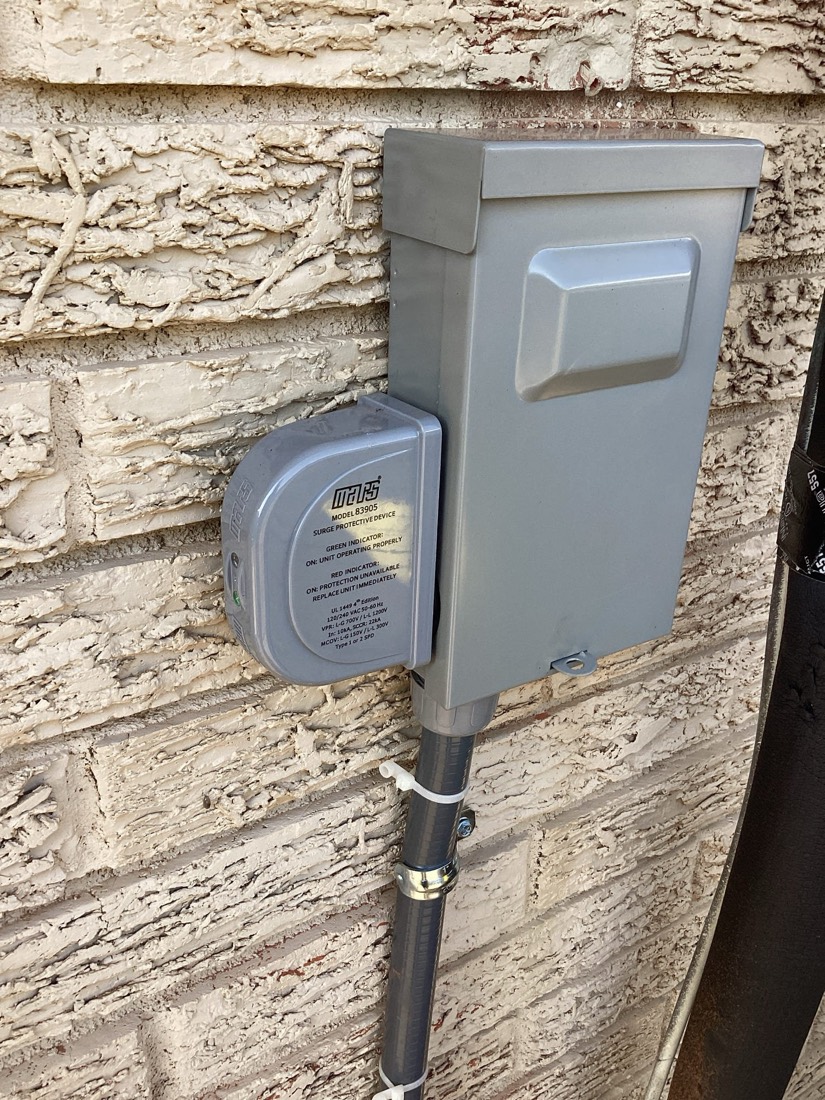 Electrical breaker box and meter mounted on brick wall