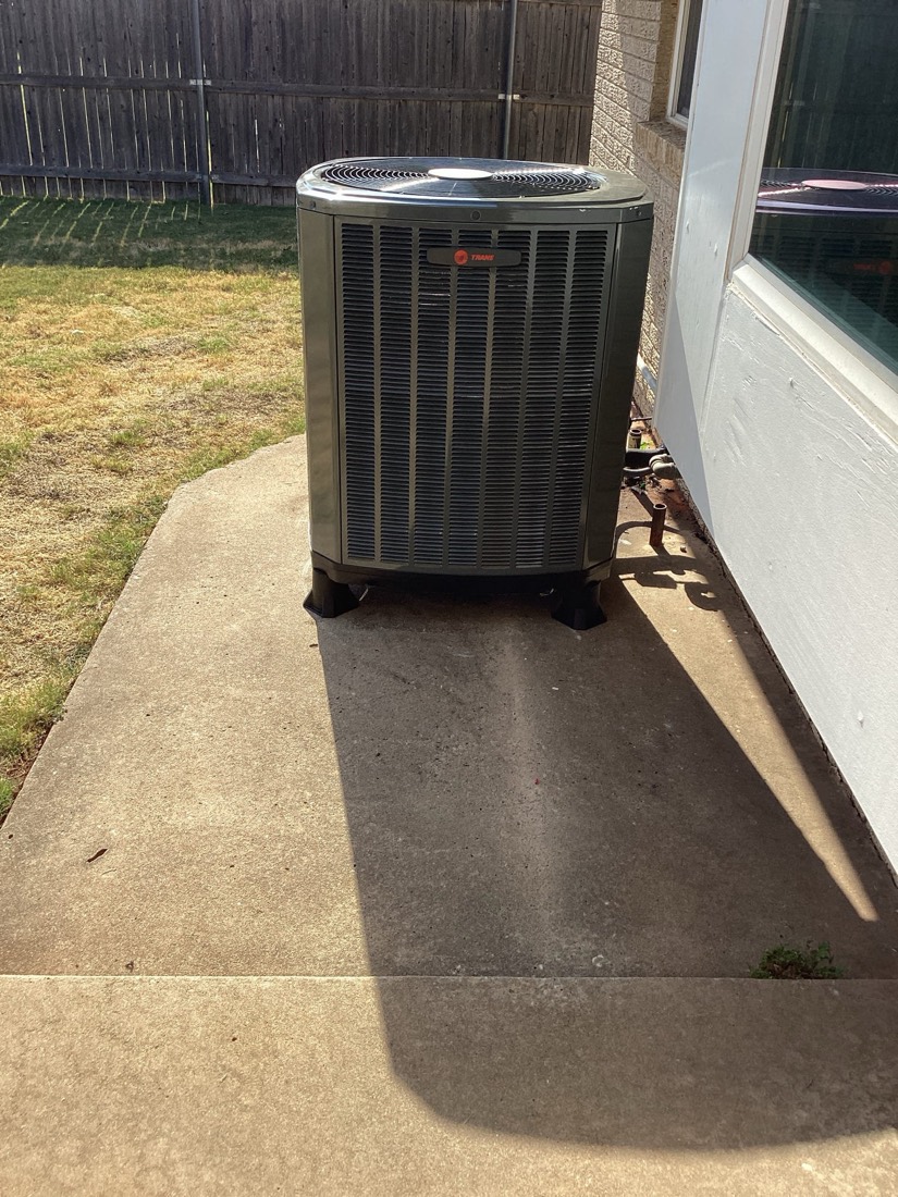 Air conditioning condenser unit on concrete pad