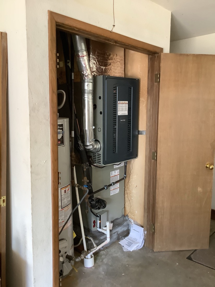 Professionally installed HVAC furnace and air handler system inside utility closet.