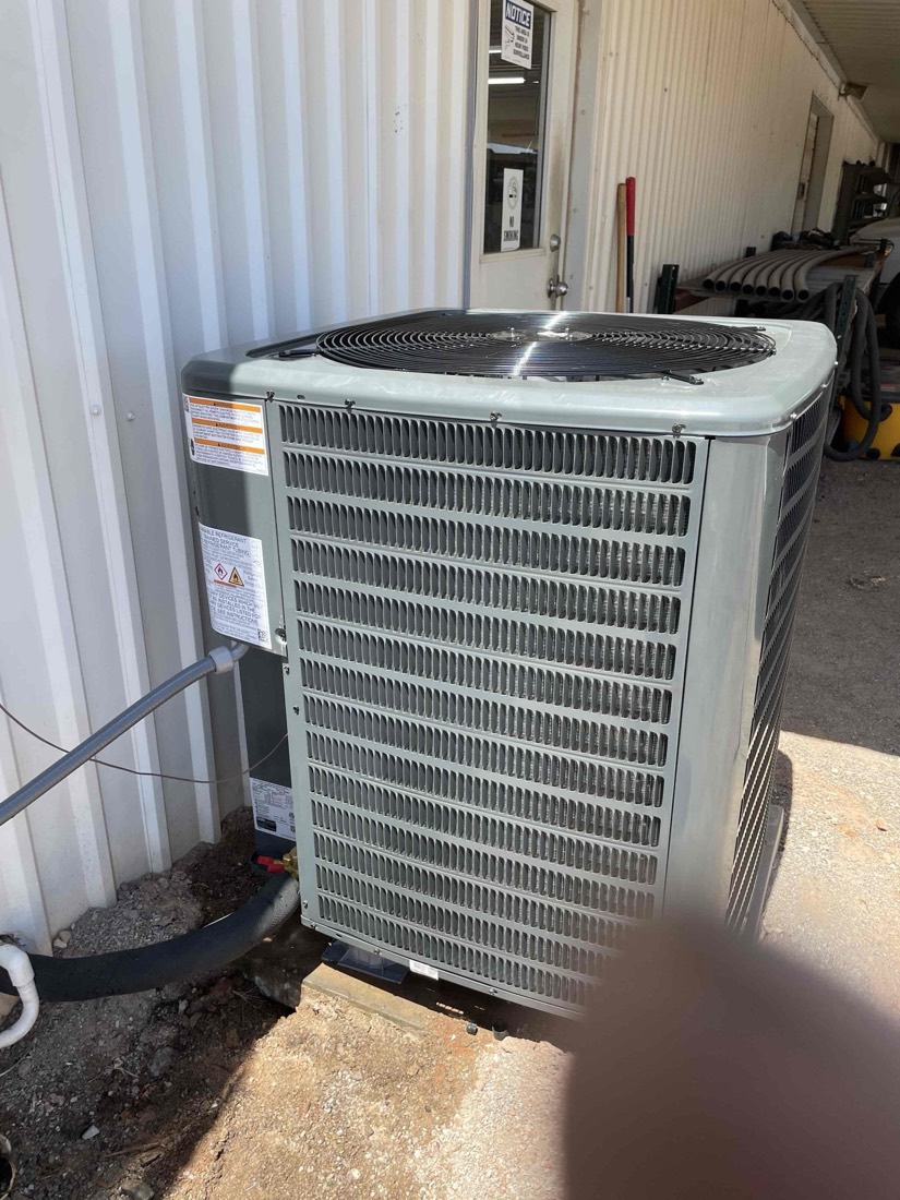 Installed outdoor AC condenser unit with refrigerant gauges
