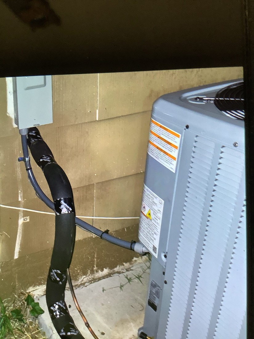 New air conditioning condenser with refrigerant lines installed.