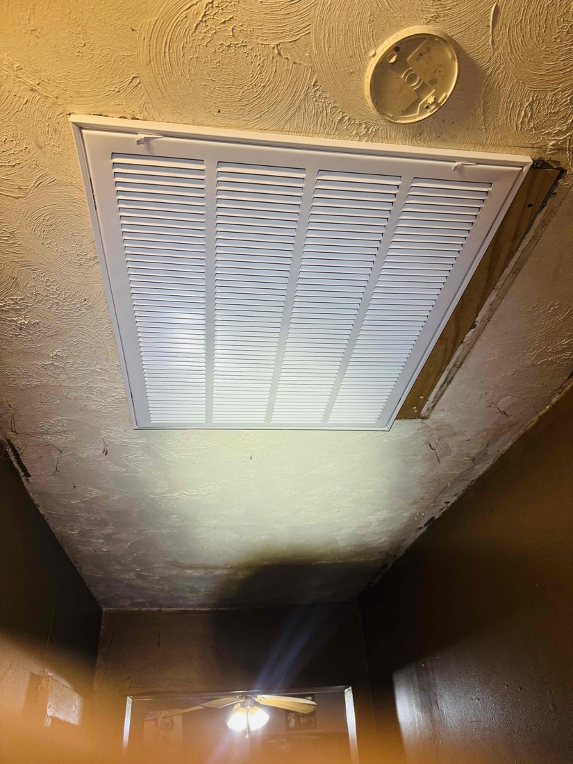 Clean white rectangular ceiling vent newly installed in home.