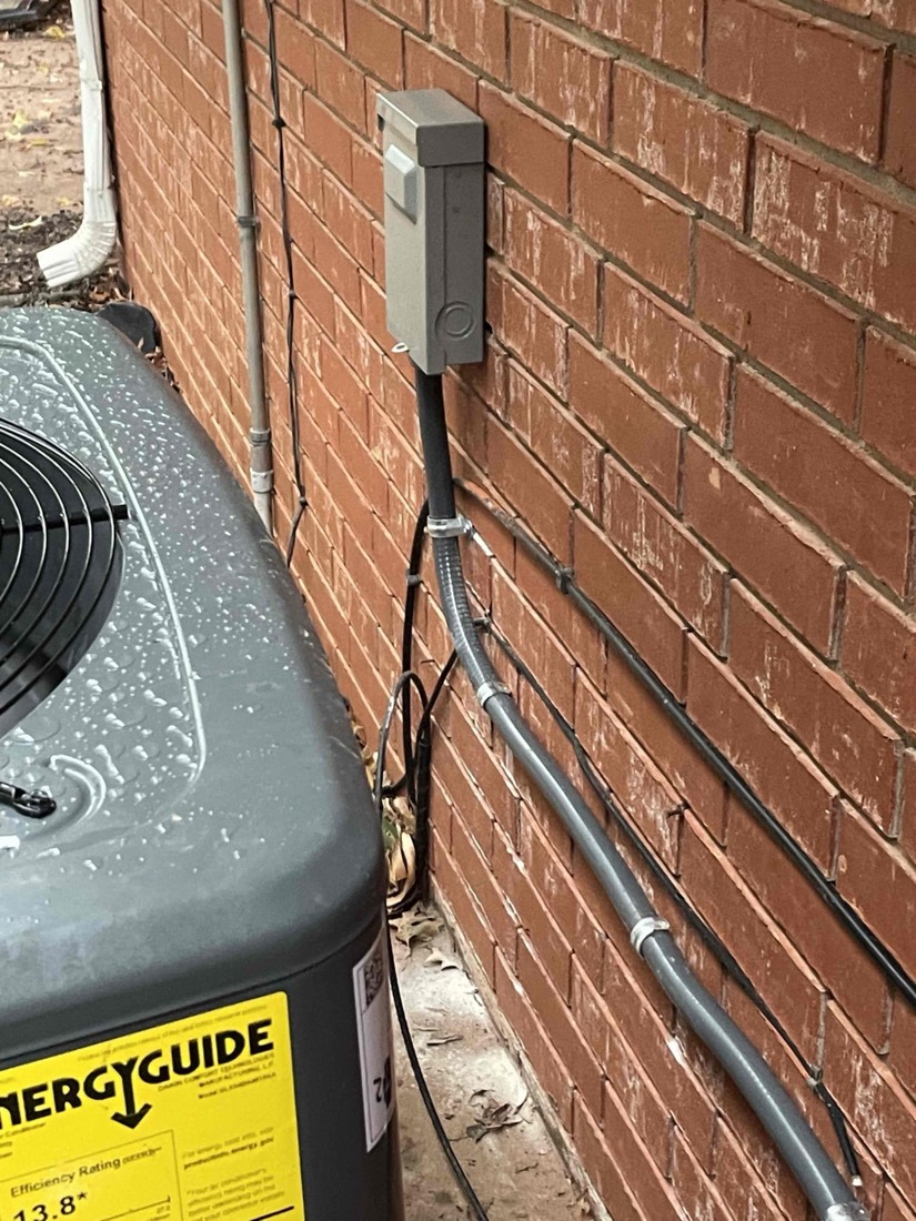 Installed AC condensate drain with copper tubing on brick wall.