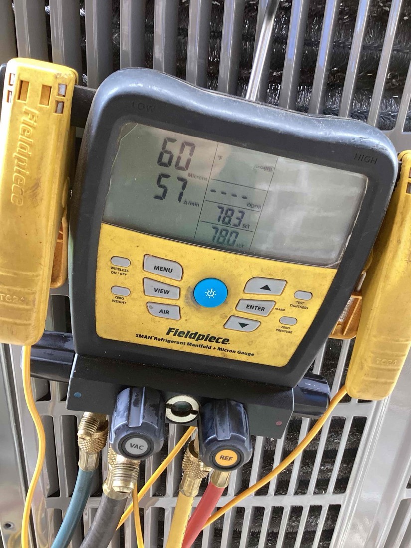 Manifold gauge displaying pressure readings during system charging.