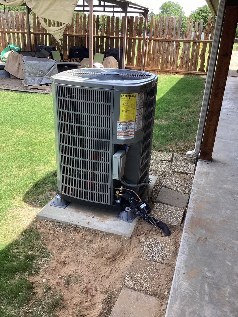 Newly installed air conditioning unit on pad with clear equipment visible.