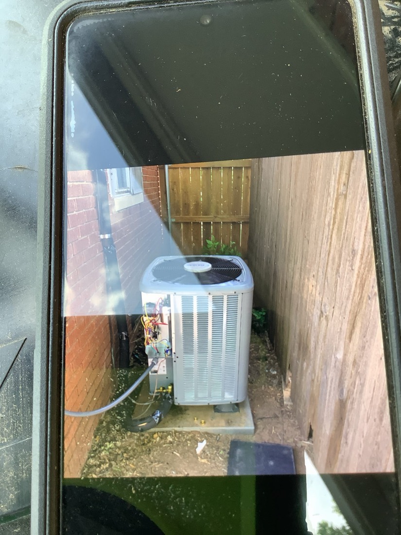 New AC condenser unit installed on concrete pad outside home
