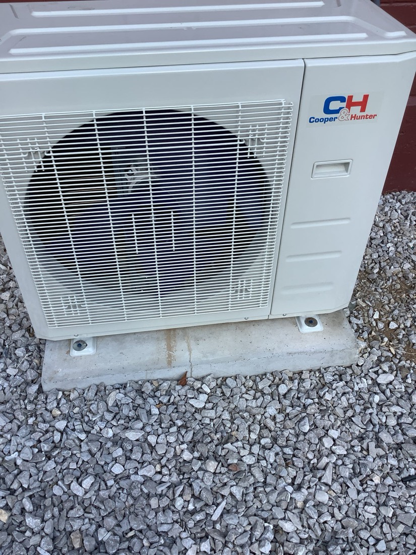 Cooper & Hunter mini-split condenser unit on concrete pad with gravel surround
