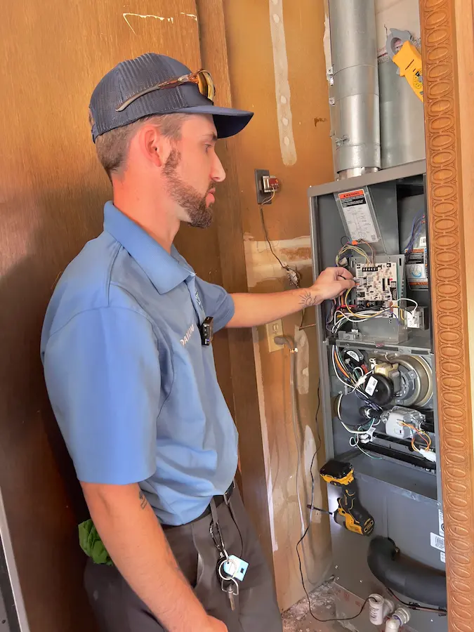Man inspecting furnace Heating Repair Edmond