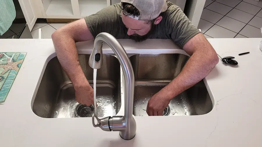 man checking kitchen pipes Plumbing Edmond